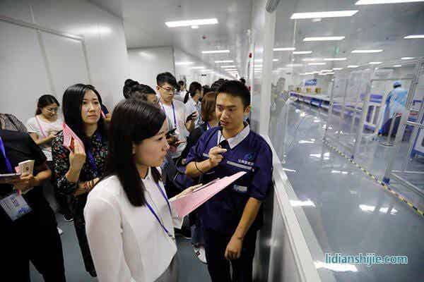 華億比科工作人員向采訪團記者介紹鋰電池生產線